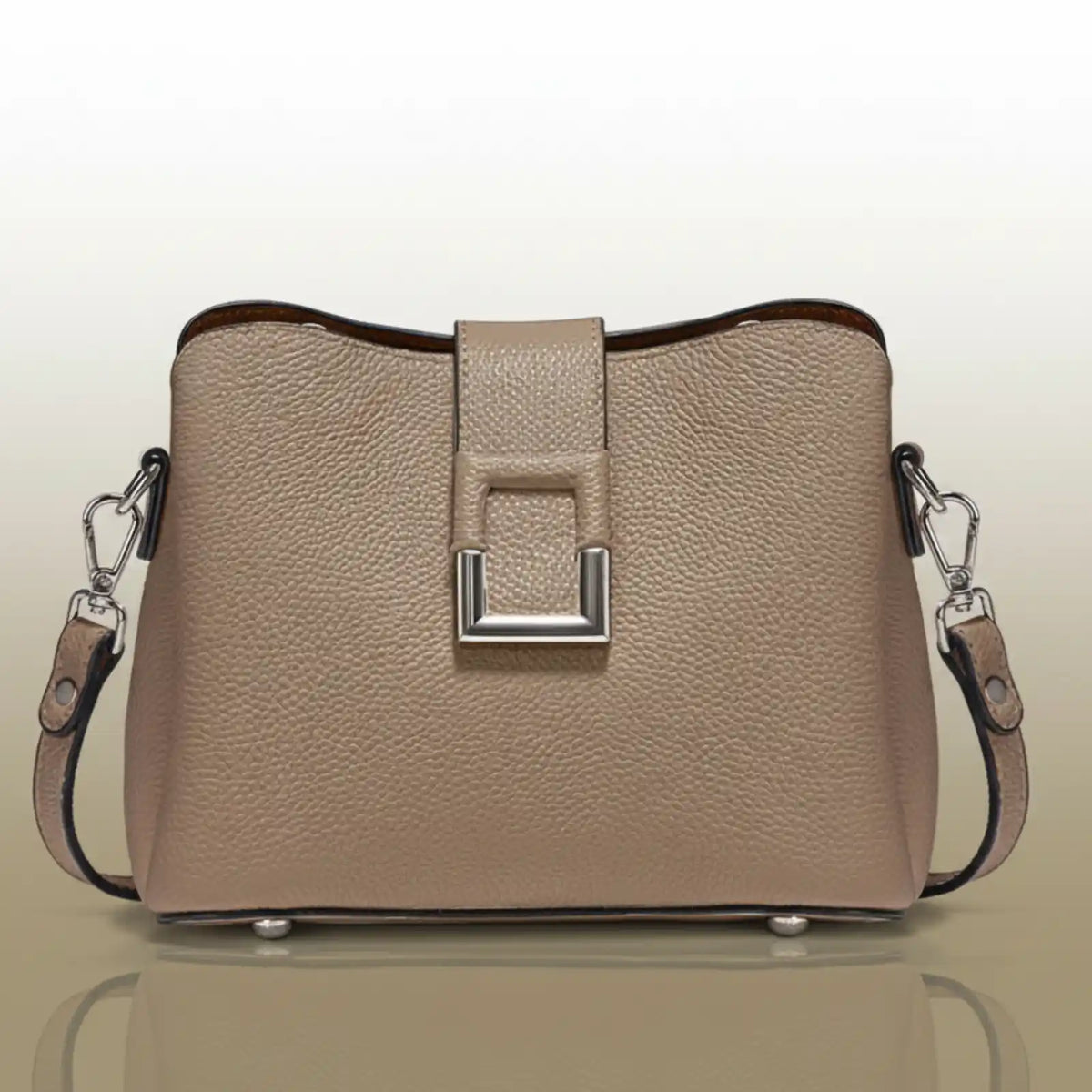 The main subject is a handbag. It's a light beige or taupe color with a textured surface.